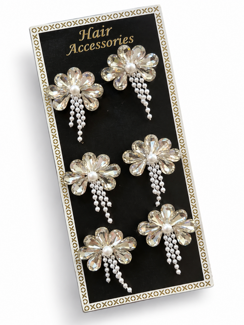 Clear crystal flower hair stickers with pearl centres displayed on a black card